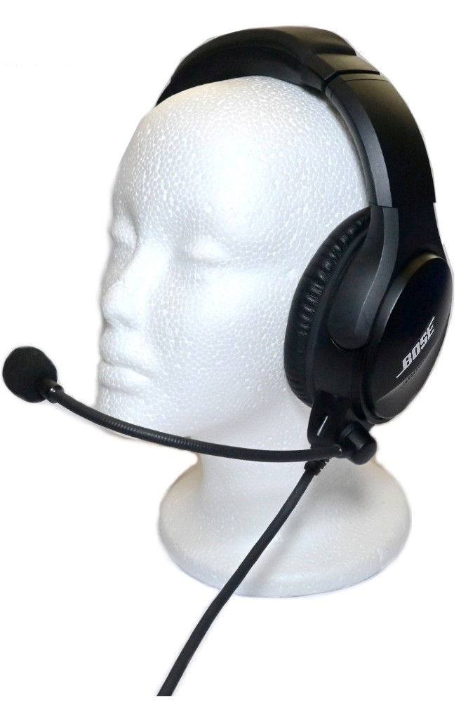 Black over-ear Bose headset with adjustable boom mic worn on a foam head mannequin, wired for use in calls or gaming